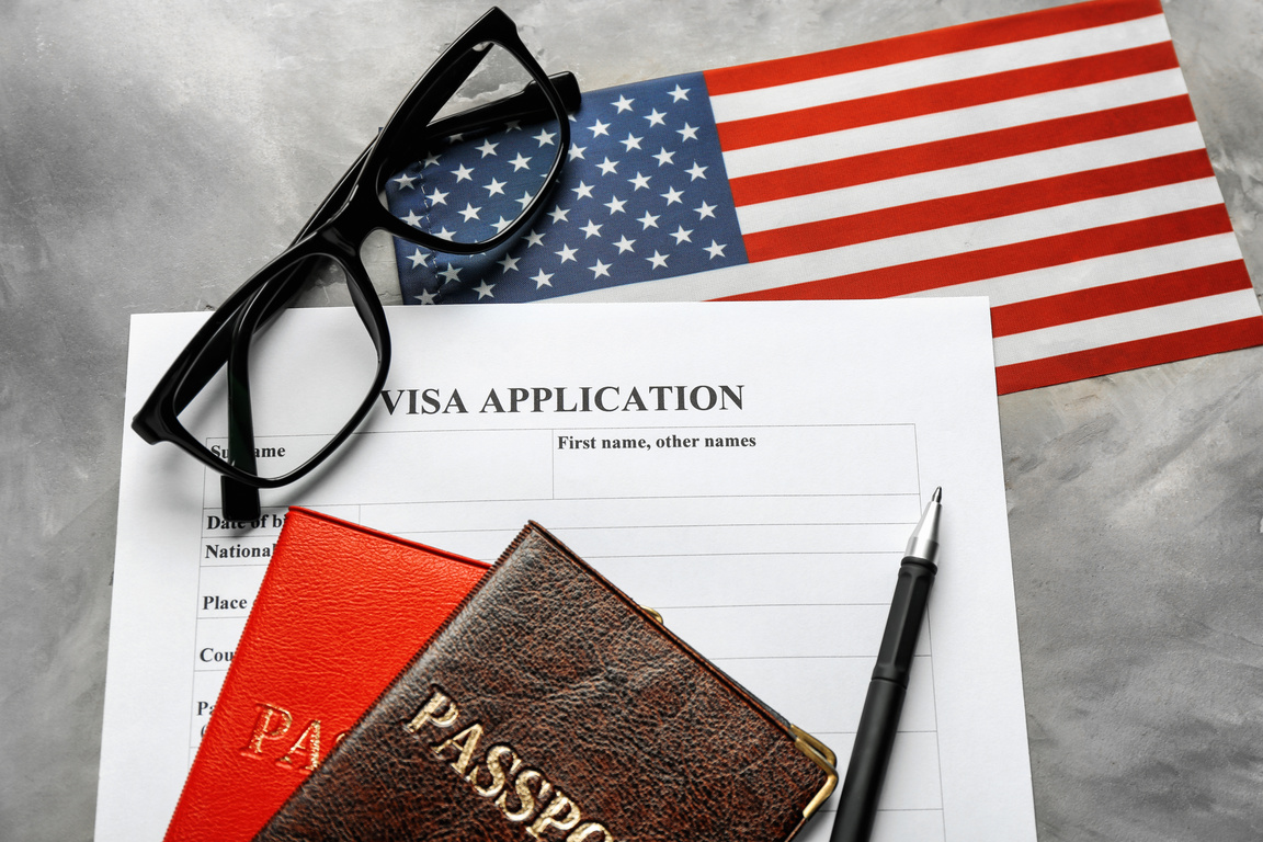 Passports, American Flag and Visa Application Form on Table