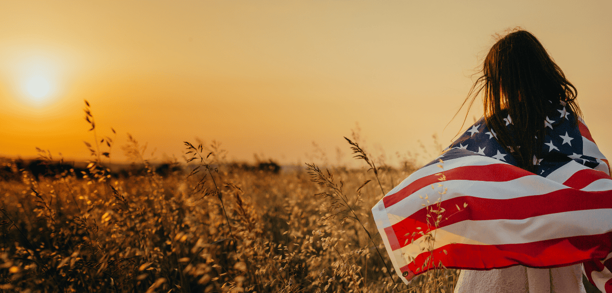 Image of an immigrant child wrapped in a US Flag